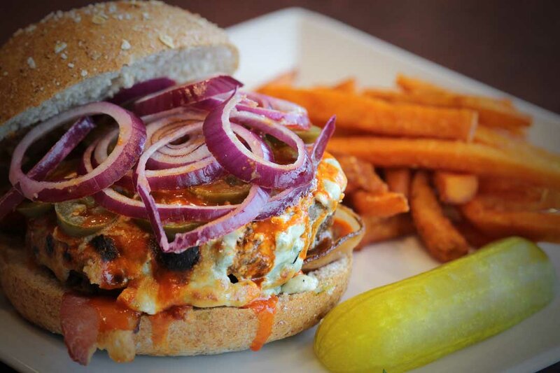 Close up view cheeseburger with side of french fries and pickle